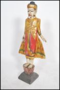A carved wooden painted Indonesian ? Thai Deity. The figure raised on a plinth base standing with