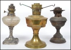 A collection of 3 early 20th century oil lamps to include a mottled glass reservoir example, brass