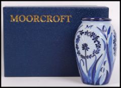 A Moorcroft pottery vase tube lined decorated in the Leila pattern on a blue ground, impressed