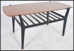 A retro 1970's Nathan teak and ebonised rectangular coffee table being raised on shaped ebonised