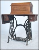 A 19th century Walnut Singer sewing machine raised on a cast iron treadle base, fitted frieze