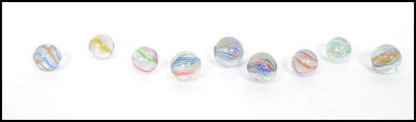 A group of nine 19th century Victorian latticino swirl ribbon air twist marbles having pontil