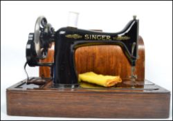 An early 20th century dome top oak cased Singer sewing machine. The case complete with key and