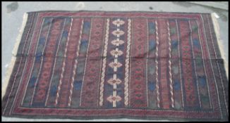 An Afghan / Persian Balouch Kilim rug having dark central ground with central runs of spiral