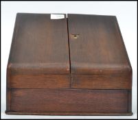 A vintage 1920s oak metamorphic oak desk top stationary chest opening to reveal a fully appointed
