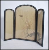 An early 20th century Japanese silk embroidered ebonised glazed three fold screen by S. Iida