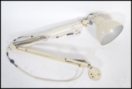 A retro 20th century wall mounted angle poise desk lamp with adjustable arm in cream colourway