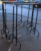 A set of five industrial clothing rails in ebonised steel of usual form raised on castors