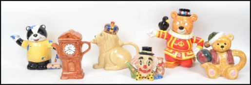 A collection of 20th century ceramic novelty tea pots to include PK lion teapot, Wade conservatory