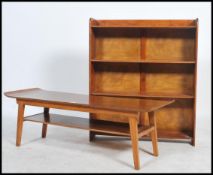 A 1970's retro teak wood surfboard style coffee table being raised on squared legs with shaped