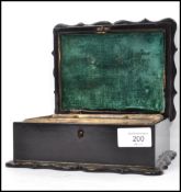 A 19th century black lacquered papier mache work box having a serpentine lid with painted decoration