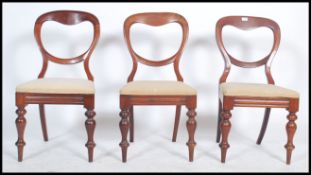 A set of 3 Victorian mahogany balloon back dining chairs being raised on turned legs with drop in