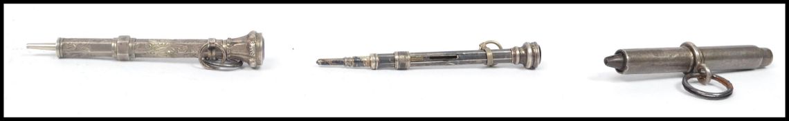 A group of propelling pencils of miniature form, two silver examples having chased decoration with