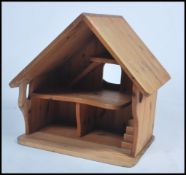 An unusual 20th century pine bird table in the form of a house having a pitched roof with interior