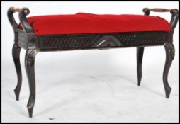 An early 20th century Edwardian piano duet window seat stool having carved legs with scrolled