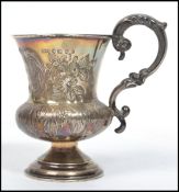 A Victorian silver hallmarked George Unite christening mug being rococo chased with cartouche marked