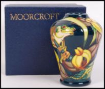 A Moorcroft ceramic tube lined vase decorated in the Amazon Collection pattern with impressed