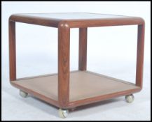 A vintage retro 20th century teak wood G-Plan square coffee table having a glass insert raised on