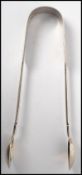A pair of Victorian silver hallmarked sugar tongs hallmarked for John Stone of Exeter dating to