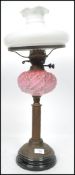A 19th century Victorian oil lamp raised on a stepped circular base with readed column cranberry