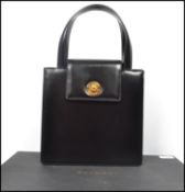 Bvlgari. A black textured leather handbag of square shape with front flap, silver hardware and
