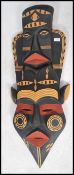 A 20th century large African tribal art wall mask of colourful decorative elongated form having twin