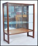 A vintage teak wood 20th century display cabinet with squared solid teak outer frame, mirror back