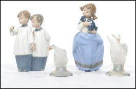A pair of vintage 20th century Lladro ceramic geese along with a Nao figurine group of choir boys