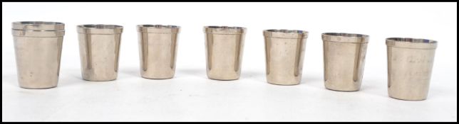 A set of eight silver white metal stacking toddy cup drink measures of typical form. Measures: 4cm