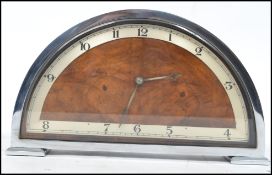 A vintage 20th century Art Deco chrome and walnut mantel clock of half moon form with silvered