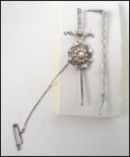 A sterling silver brooch in the form of a riding crop by Alfred James How (1892-1929 ) measuring