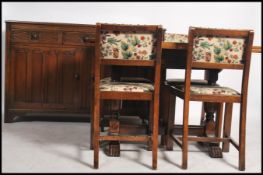 A 1930's oak dining room suite comprising a draw leaf dining table together with the 4 chairs and an