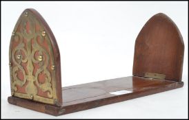 A 19th century Victorian walnut and brass bound book slide having applied Gothic style fret work