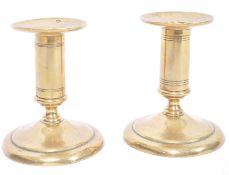 A small pair of early 19th century brass candlesticks of seamed construction and unusual form having
