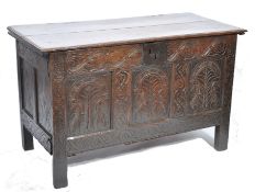 An 18th century West Country oak coffer chest. Raised on stile supports with carved fielded front