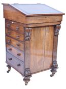 A 19th century rosewood davenport desk raised on bun castors having upright pedestal with faux