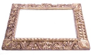 An early 19th century overmantel mirror having a florentine manner ornate gilt decorated wooden