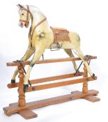 An early 20th century wooden rocking horse in the manner of Collinson. Set over a wooden glider with