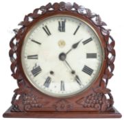 A GWR railway station clock set within a mahogany frame with flower head borders to the circular