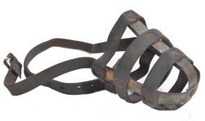 A 19th century leather and strap metal performing bear muzzle. Cross over metal strap work with