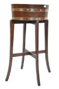 A 19th century coopered oak and brass bound barrel planter by Lister of Dursley. Raised on squared