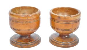 A pair of early 19th century fruitwood treen salts being ring turned and step bases. Each measures
