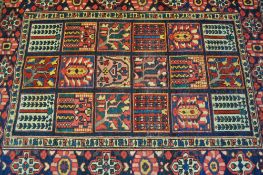 An early 20th century Persian carpet hand woven floor rug having a blue and red ground. The