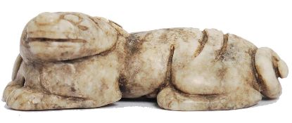 A Chinese white mottled jade scroll weight / pendant in the form of a recumbent mythological dog.