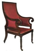 A 19th century Regency library / salon armchair of mahogany construction being raised on turned