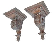 A pair of 19th century large solid walnut carved wall brackets rising from inverted finial bases