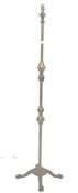 A 19th century brass and iron based standard lamp raised on a quadruped base with lion paw feet. The