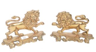 A pair of 19th century brass flat back fire side dog figurines in the form of lions. The lions