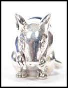 A silver mouse pin cushion having baize lined top