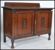 A 1930's oak low sideboard cabinet raised on bun f